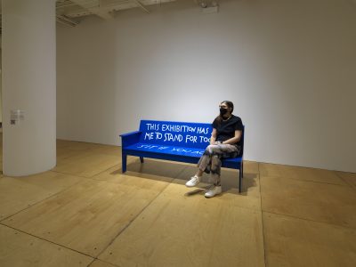 Person sitting on a blue bench.