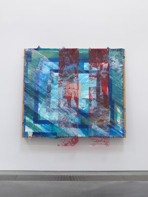 Mixed media artwork in blue and red on a white gallery wall.
