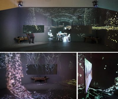 Three images of a dark room from three different angles showing screens and many dots of light.